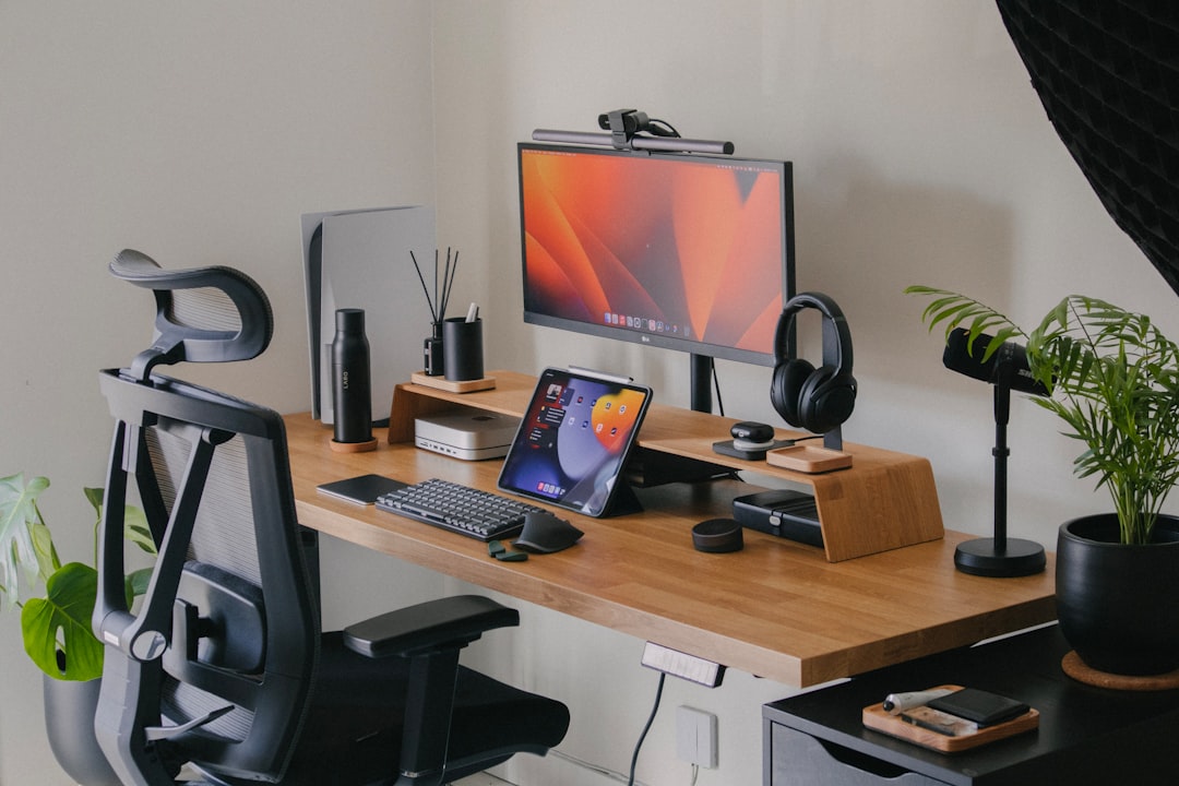 minimalist home office setup with a wooden desk, laptop, lamp, notebook, and soft natural light